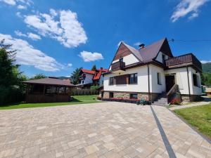 a house with a driveway in front of it at Apartamenty Kolorowa in Szczyrk