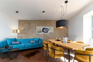 een woonkamer met een blauwe bank en een houten tafel bij CASA GIUSEPPE Luxury house with an amazing view in Labin