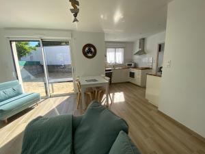 salon z kanapą i stołem oraz kuchnia w obiekcie DOMUS AUREA Maison Dorée w mieście Jard-sur-Mer
