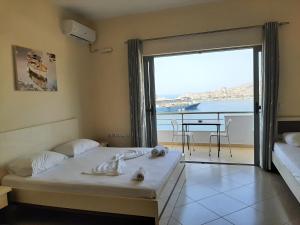 a bedroom with a bed and a view of the ocean at Bill's Apartments in Sarandë