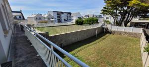 d'un balcon avec une clôture et une cour. dans l'établissement T3 “Belle-île“- 50 m de la plage de Fort Bloqué/Ploemeur, à Ploemeur