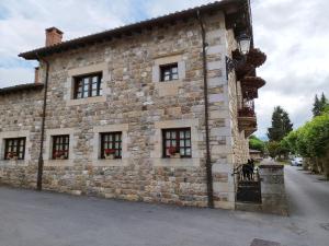 a stone building with windows on a street at Apartamentos Villa Julieta in Ruente
