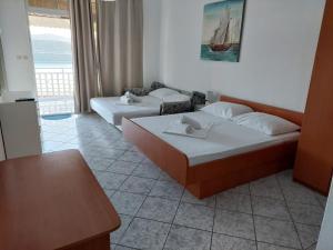 two beds in a room with a view of the ocean at Apartments Menalo in Neum