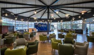 a lobby with chairs and tables in a building at Ohtels Carabela in Matalascañas