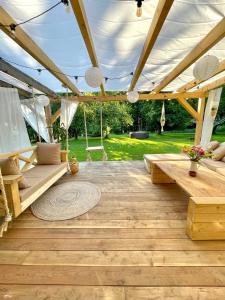 a pavilion with a table and benches on a patio at Gajówka in Węgorzewo