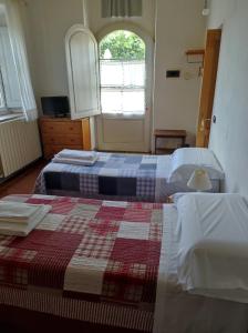 two beds in a room with a window at Agriturismo Le Cantine in Poggibonsi