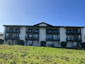 a large white building with balconies on a hill at Studio Églantine à Cambo-les-Bains, proche thermes, terrasse, parking, accès Internet, animaux OK - FR-1-495-106 in Cambo-les-Bains