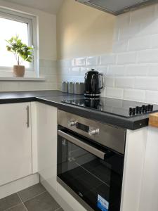 a kitchen with a stove top oven next to a window at Comfortable King Bed - Location - Contractors - Family - Parking in Bedford