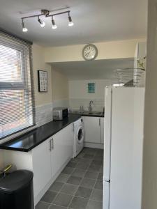 a kitchen with a refrigerator and a clock on the wall at Comfortable King Bed - Location - Contractors - Family - Parking in Bedford