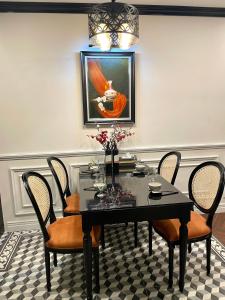 una sala da pranzo con tavolo, sedie e un quadro di TMS Pullman Quy Nhơn The Maison House a Quy Nhon