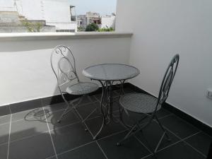 2 sillas y una mesa en una habitación con ventana en B&B WHITE HOUSE, en Pulsano