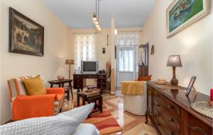 ein Wohnzimmer mit orangefarbenen Stühlen und einem TV in der Unterkunft 3 Bedroom Nice Home In Crikvenica in Crikvenica
