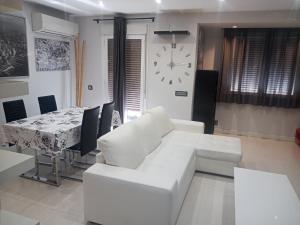 a living room with a white couch and a table with a clock at apartamento COLON !!PARKING PRIVADO GRATUITO !! in Logroño