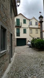 una strada di ciottoli di fronte a un edificio di Casa do Pelourinho - T0 a Loriga