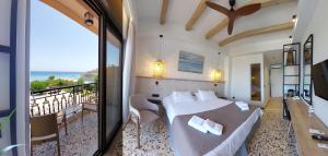 a bedroom with a bed and a balcony with the ocean at Anetis Hotel in Tsilivi