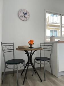 uma mesa e cadeiras numa cozinha com um relógio na parede em CORNELIA`S HOME TC2 preciosas vistas em Los Cristianos