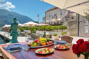 a table with plates of food on top of a table at Hotel Splendido in Kotor