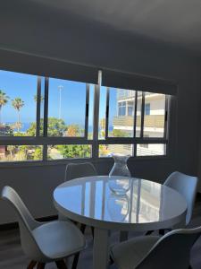 uma mesa e cadeiras num quarto com janelas em CORNELIA`S HOME TC2 preciosas vistas em Los Cristianos