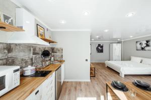 a kitchen and living room with a bed in the background at Квартира-студия в центре Публика in Petropavlovsk