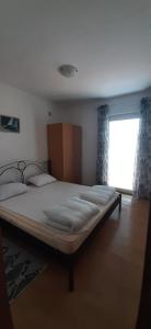 duże łóżko w pokoju z oknem w obiekcie Villa Dobra Family Apartments w mieście Vir