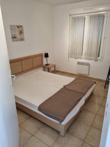 1 dormitorio con cama y ventana en Appartement T2 dans résidence avec piscine, en Moriani Plage