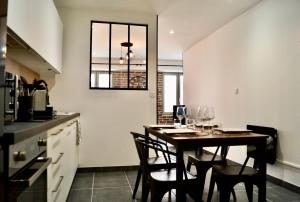 una cocina con una mesa con copas de vino. en L'atelier en Crest