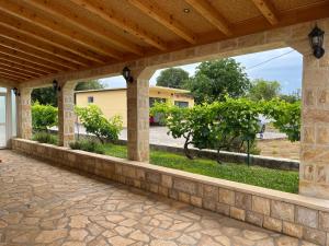 an outdoor patio with a stone wall and a wooden roof at Runaway Cottage in Unešić