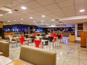 uma sala de jantar com mesas e cadeiras e um restaurante em ibis Rio de Janeiro Nova America no Rio de Janeiro