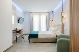 a bedroom with a bed and a desk and a chair at Nerja VG Hostal Boutique in Nerja