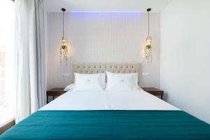 a bedroom with a large white bed with two pillows at Nerja VG Hostal Boutique in Nerja