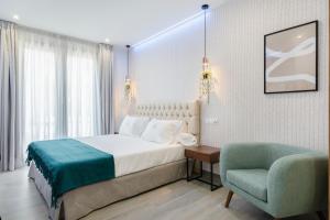 a hotel room with a bed and a chair at Nerja VG Hostal Boutique in Nerja