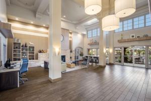 a large room with a lobby with a desk and chairs at MainStay Suites John Wayne Airport, a Choice Hotel in Santa Ana