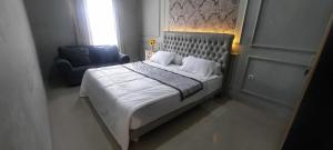 AL Isyania Creative Homestay Syariah في Gadut: غرفة نوم بسرير وكرسي ازرق