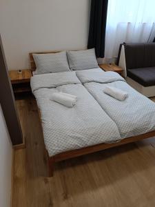 a bed in a room with two pillows on it at Apartments Aura in Deskle
