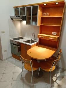 uma pequena cozinha com uma mesa de madeira e cadeiras em Apartments Aura em Deskle