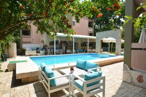 a pool with chairs and a table next to a building at Dimitriadis fresh Edem in Limenas