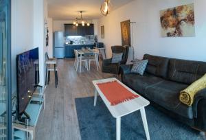 een woonkamer met een bank en een tafel bij Mali apartment Varna in Varna