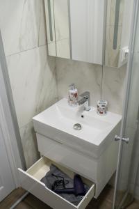 a bathroom with a white sink and a mirror at Mali apartment Varna in Varna City
