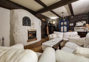 a living room with white couches and a fireplace at U Lawendowej Wiedźmy in Istebna