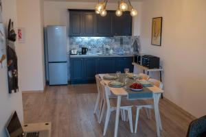 Mali apartment Varna في مدينة فارنا: مطبخ مع طاولة مع كراسي وثلاجة