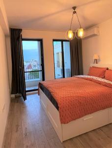 a bedroom with a bed and a large window at Mali apartment Varna in Varna City