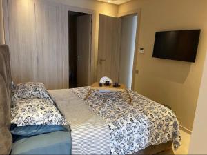 a bedroom with a bed with a table on it at Cosy appartement à Ain Diab beach in Casablanca