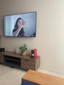 a television on a wall with a woman on it at Cosy appartement à Ain Diab beach in Casablanca