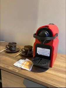 a red coffee maker sitting on top of a table at Cosy appartement à Ain Diab beach in Casablanca