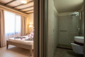 ein Badezimmer mit einem Bett, einer Dusche und einem Waschbecken in der Unterkunft Studios Limnionas in Marathokampos