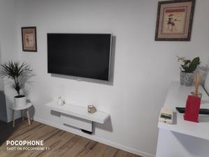 - un salon avec une télévision sur un mur blanc dans l'établissement Garden apartment Vanya, à Split