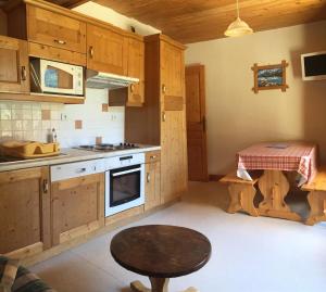 een keuken met houten kasten en een tafel. bij Appartement Montana 8 in Pralognan-la-Vanoise