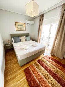 1 dormitorio con cama y ventana grande en Peaceful Apartment by Flisvos Marina by Athenian Homes, en Atenas