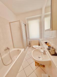 uma casa de banho com um lavatório, uma banheira e um WC. em Jade FeWo Cottbus em Cottbus