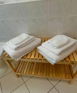 Duas toalhas numa plataforma de madeira na casa de banho em Jade FeWo Cottbus em Cottbus